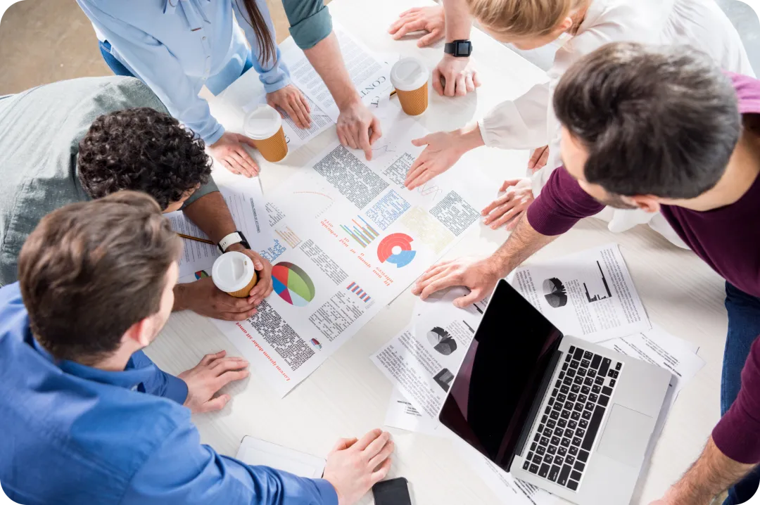Marketingteam plant Online-Kampagnen mit Laptop und Charts