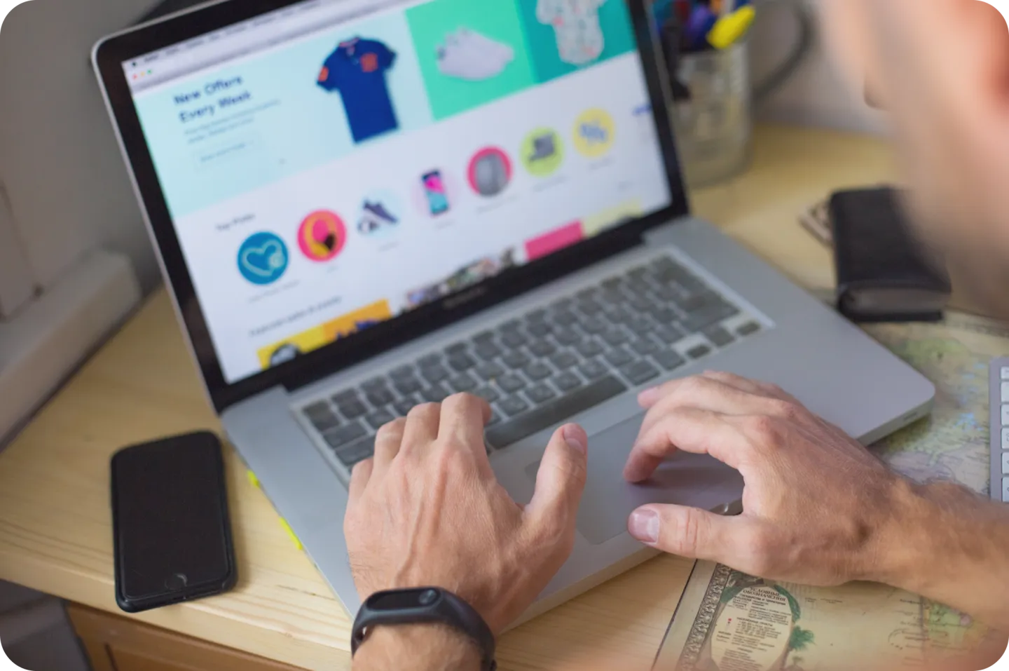 Person arbeitet am Laptop mit Online-Shop-Design im Browser