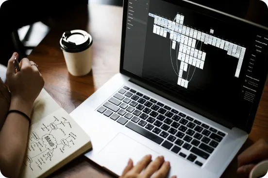 Wireframe eines digitalen Produkts auf einem Laptop neben Skizzenbuch
