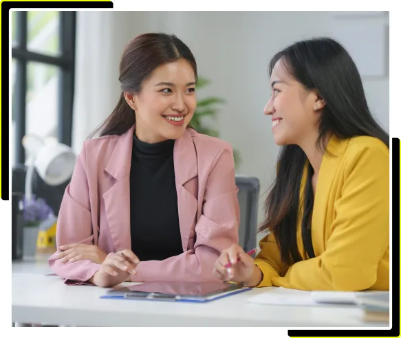 Zwei Frauen besprechen CRM-Strategien mit Greyhound auf einem Tablet
