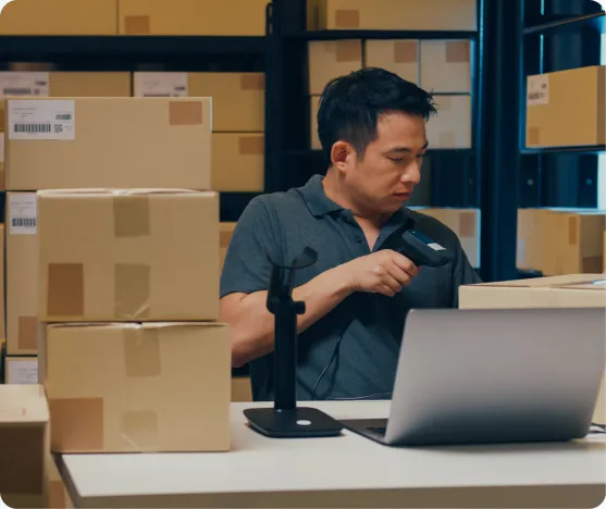 Lagermitarbeiter erfasst Pakete mit einem Barcode-Scanner